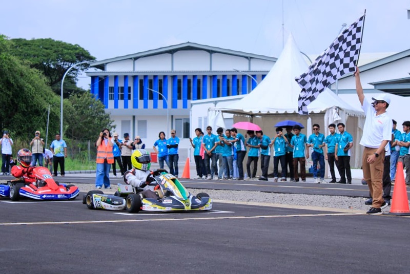 Rektor ITS Prof Dr HC Ir Bambang Pramujati ST MScEng PhD mengangkat bendera start saat memulai Kompetisi Gokart Listrik PLN ICE 2025 di Sirkuit ITS